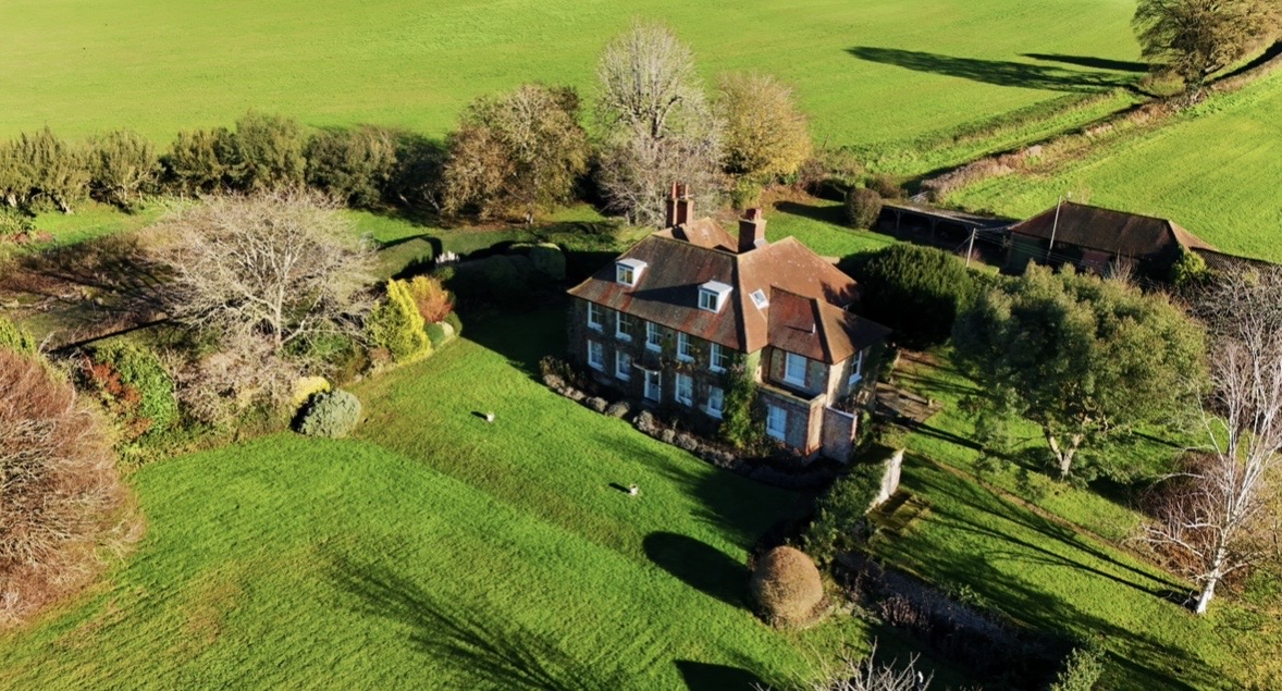 Aerial view of a country home surrounded by green grounds
